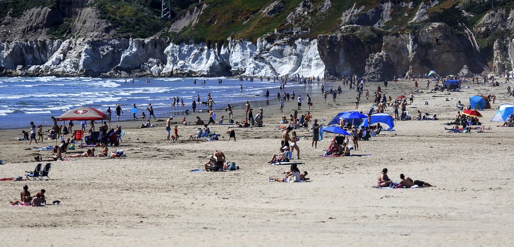 In this Saturday, April 25, 2020, file photo, people gather on the beach in Pismo Beach, Calif., on the state's Central Coast.