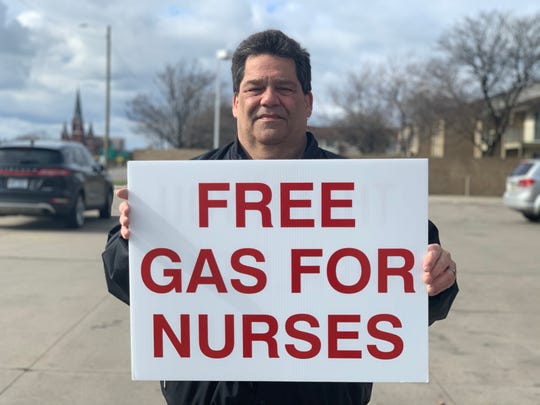 Allen Marshall, 60, of St. Clair Shores, holds a sign offering to buy free gas for nurses (Photo: Branden Hunter)