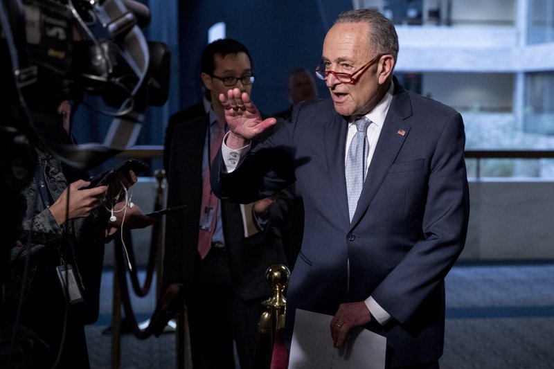 FILE - In this March 20, 2020, file photo Senate Minority Leader Sen. Chuck Schumer of N.Y., speaks to reporters as he arrives for a meeting to discuss the coronavirus relief bill on Capitol Hill Washington.