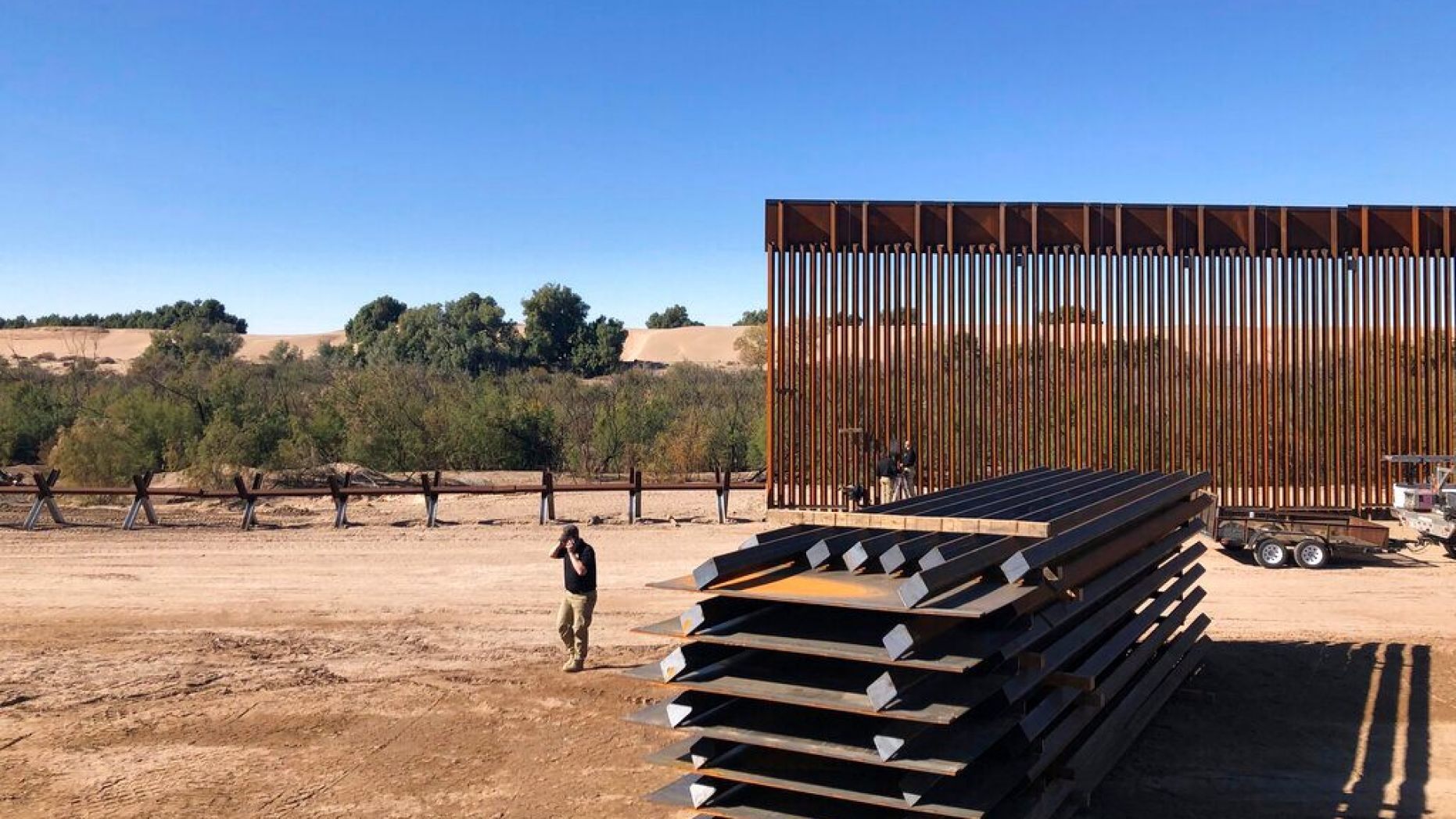 In this Jan. 10, 2020, photo, people work at a portion of border wall which is under construction in Yuma, Ariz.