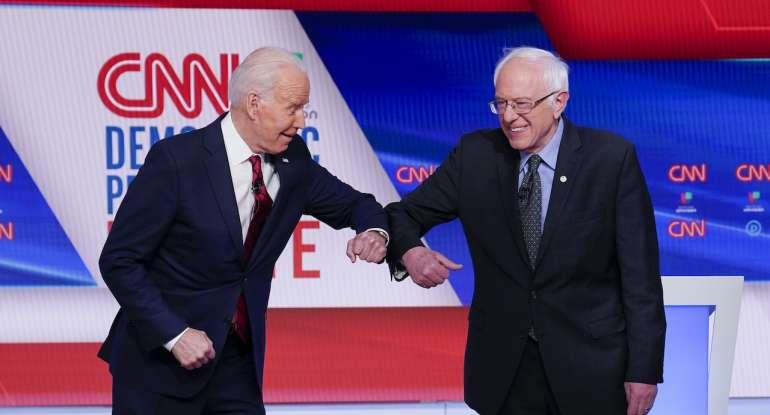 Former Vice President Joe Biden, left, and Sen. Bernie Sanders, I-Vt., right, greet one another before they participate in a Democratic presidential primary debate