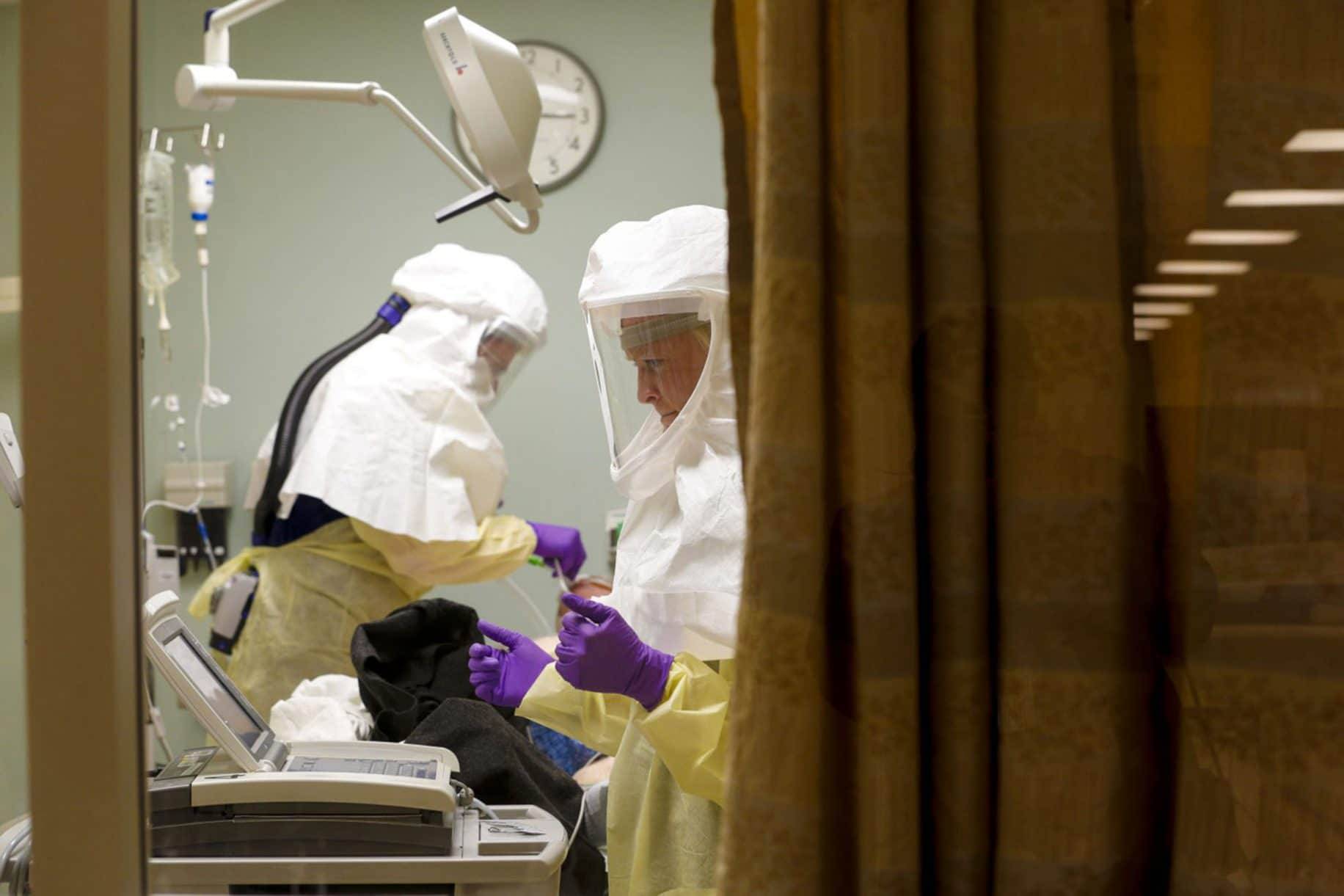 At Sharp Memorial Hospital in San Diego, nurses, wearing personal protective equipment, treat a patient diagnosed with COVID-19