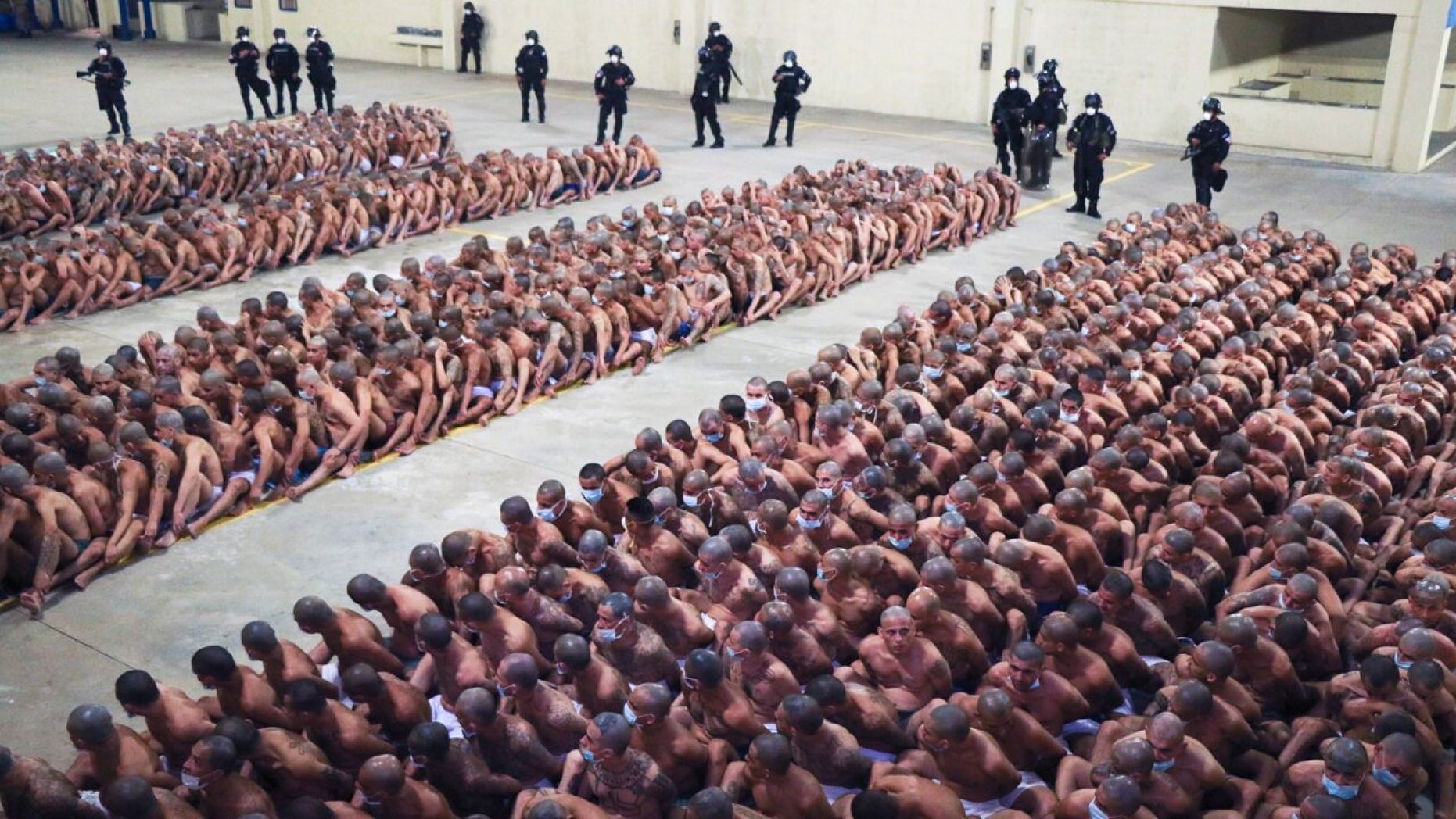 Police wearing masks as a precaution against the new coronavirus guard inmates, also wearing masks, during a security operation after President Nayib Bukele decreed maximum emergency in prisons housing gang members at the Izalco prison in San Salvador, 