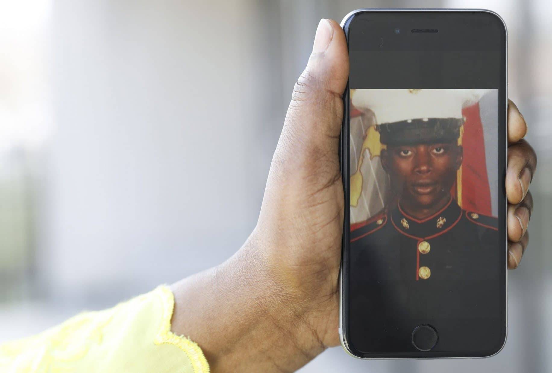 Fatoumata Balde, sister of Mamadou Balde, holds cell image of her brother as a Marine