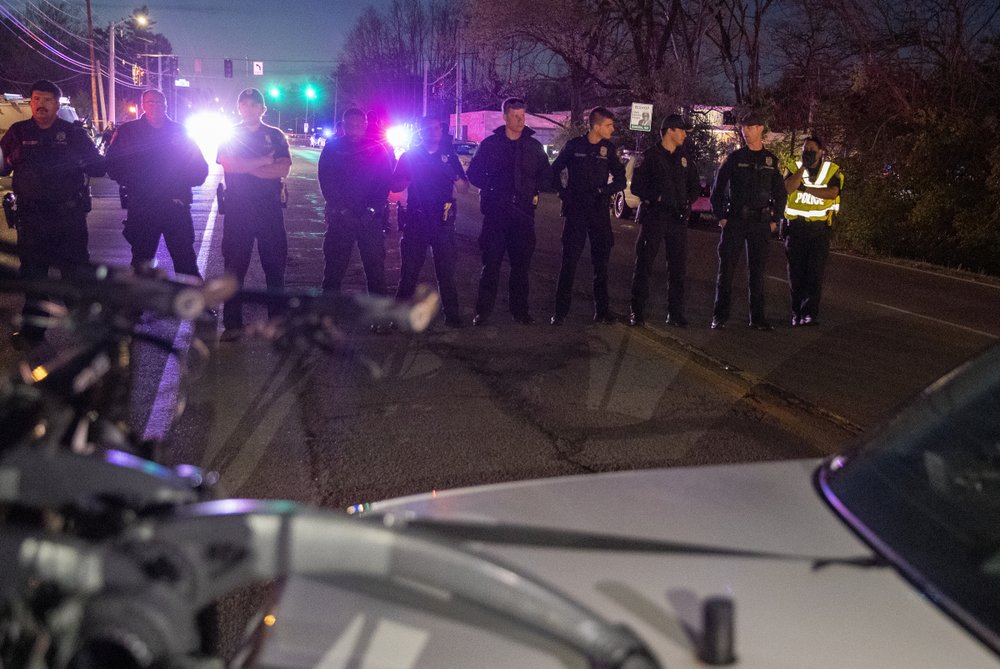 In this Wednesday, May 6, 2020 photo, police face upset community members in Indianapolis protesting hours after a man was killed,