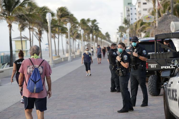 Hollywood, Fla., police officers monitor activity along the Hollywood Beach Boardwalk on Wednesday, May 13, 2020. 