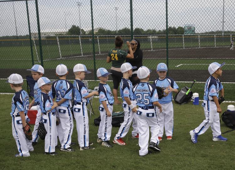 In this June 21, 2017, photo, players line up to take the field for a baseball game at the Orlando North Seminole County Sports facility in Sanford, Fla.