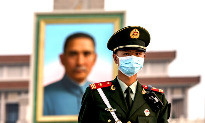 A Chinese police wearing protective masks march in front of the portrait of Nationalist founder Sun Yat-sen at Tiananmen Square in Beijing,