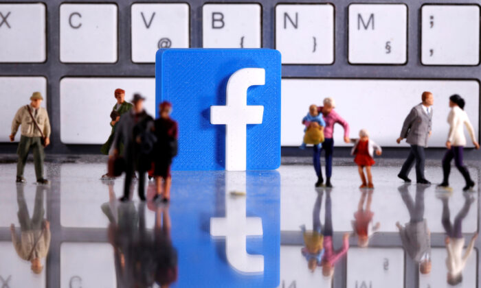 A 3D printed Facebook logo and toy people figures in front of a keyboard in this illustration taken on April 12, 2020. 