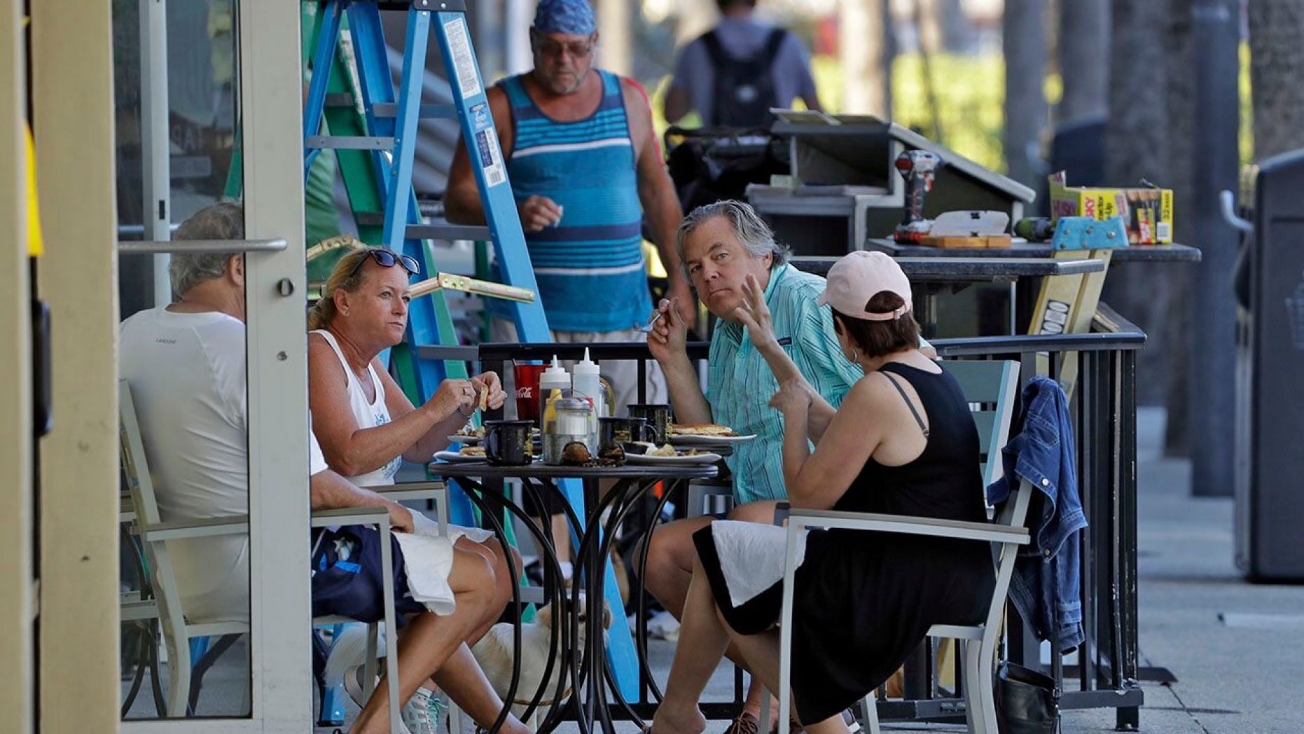 People have breakfast at a cafe Monday in Clearwater Beach, Fla.,