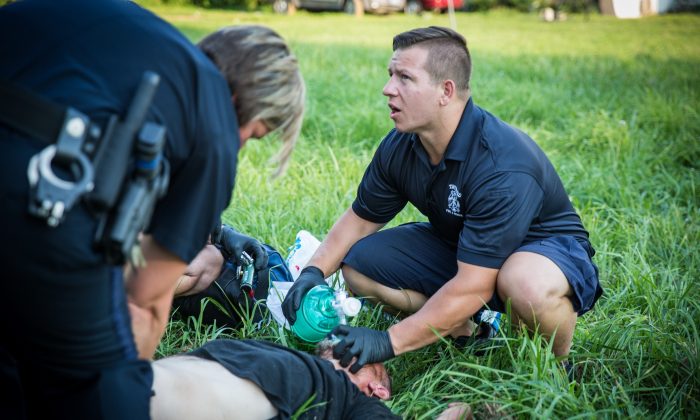 Local police and paramedics help a man who is overdosing in the Drexel neighborhood of Dayton, Ohio, on Aug. 3, 2017.