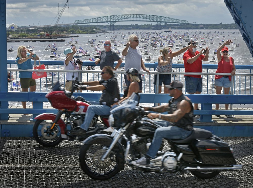 Supporters of President Donald Trump wave at motorcycles coming over the Main Street Bridge as hundreds of boats idle under the downtown bridge on the St. Johns River during a rally Sunday, June 14, 2020, in Jacksonville, Fla., celebrating Trump's birthday. 
