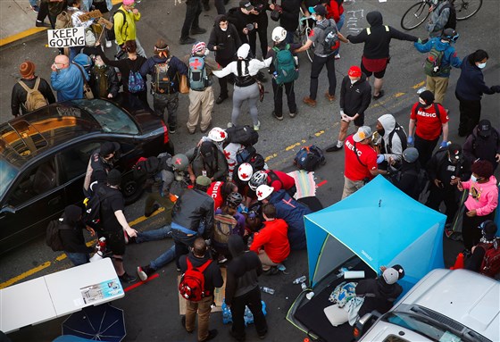 Medics tend to a man who was shot in the arm by a driver of a black vehicle at a protest against racial inequality in Seattle, Washington, on Sunday.