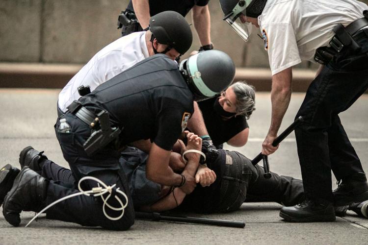 Police arrest a protester refusing to get off the streets during an imposed curfew while marching in a solidarity rally calling for justice over the death of George Floyd Tuesday, June 2, 2020, in New York.