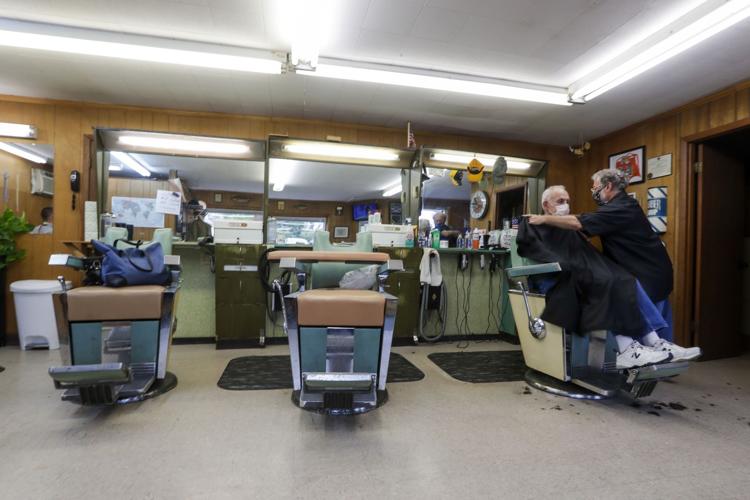Owner Paul Furrer cuts the hair of Louis Rigano at Rick's Barber Shop Thursday, May 14, 2020, in Waukesha, Wis. The store re-opened after the Wisconsin Supreme Court struck down Gov. Ever's stay-at-home order on Wednesday.