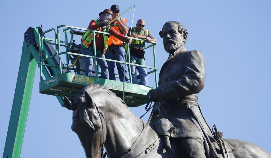 An inspection crew from the Virginia Department of General Services takes measurements as they inspect the statue of Confederate Gen. Robert E. Lee on Monument Avenue Monday, June 8, 2020, in Richmond, Va. Virginia Gov. Ralph Northam has ordered the removal of the statue.