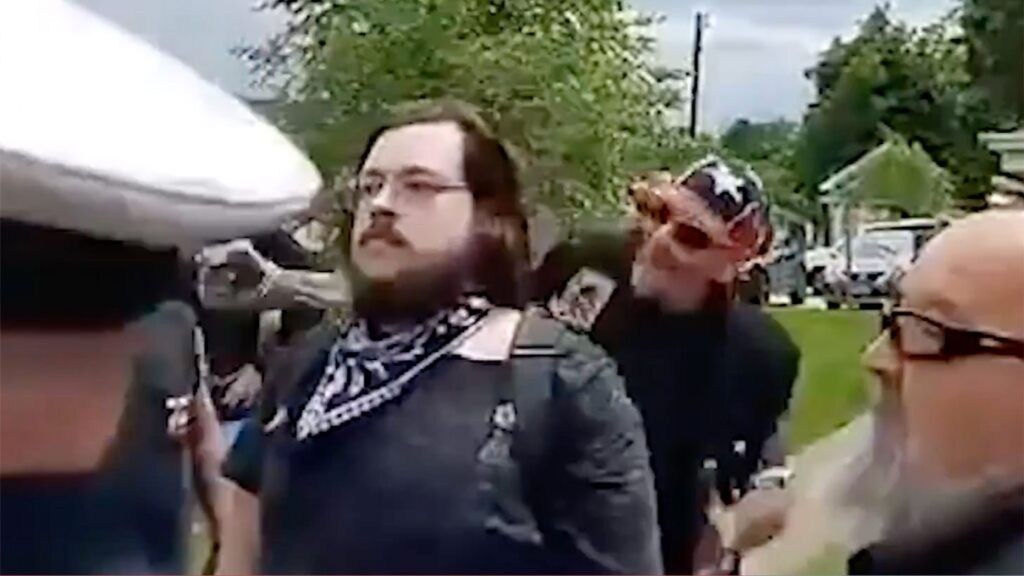 The suspect, Johnnie Devault, can be seen behind the victim Nicholas Reardon before punching him in the back of the head during a Black Lives Matter protest in Ohio Sunday. 