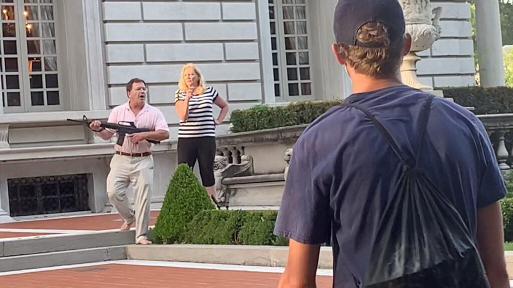 A couple draws their firearms on protestors as they enter their neighborhood during a protest against St. Louis Mayor Lyda Krewson, in St. Louis, 