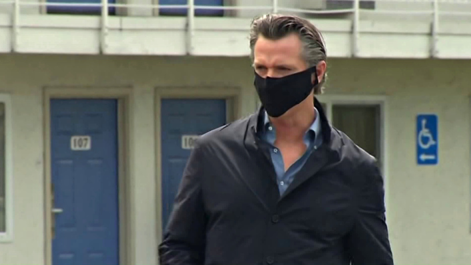 Gov. Gavin Newsom walks outside a Santa Clara County motel set to shelter homeless people amid the coronavirus pandemic ahead of a briefing on April 18, 2020.