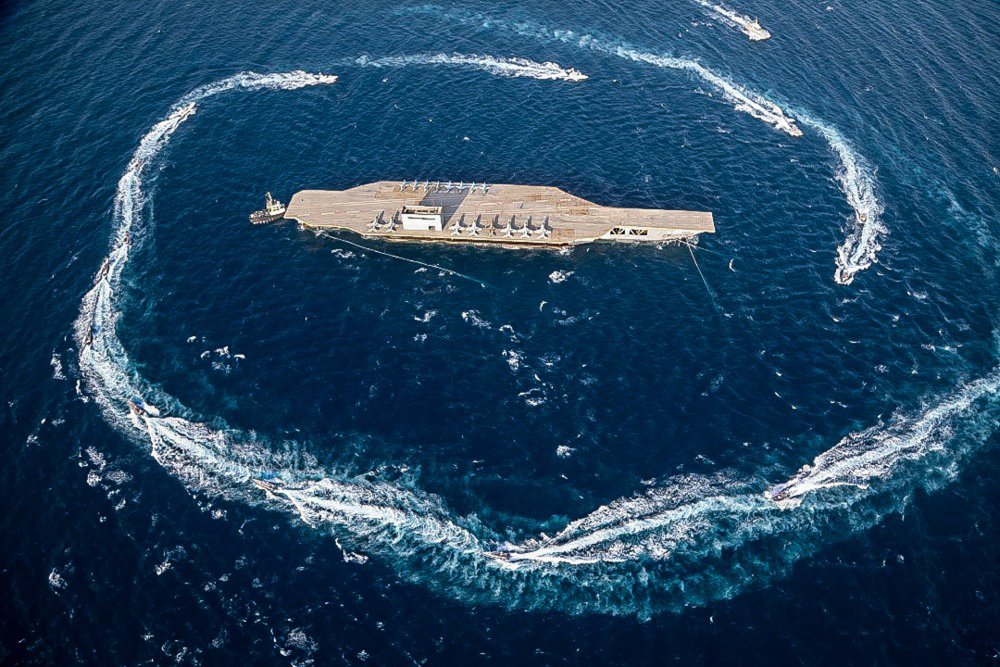 In this photo released Tuesday, July 28, 2020, by Sepahnews, Revolutionary Guard's speed boats circle around a replica aircraft carrier during a military exercise.