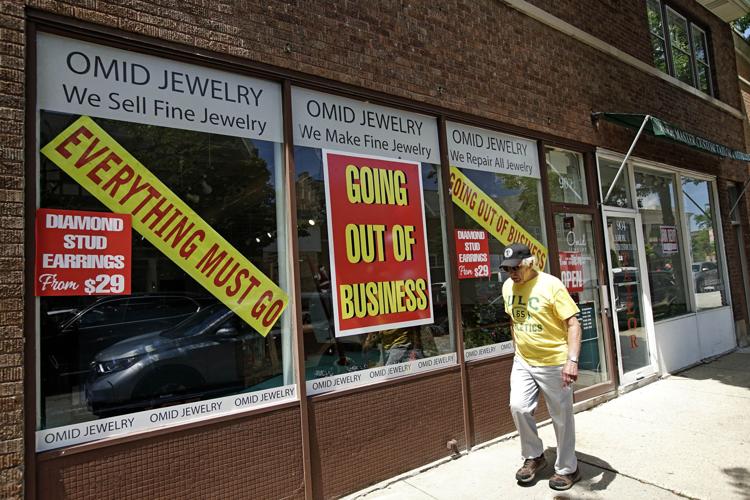 A man walks past a retail store that is going out of business due to the coronavirus pandemic in Winnetka, Ill., Tuesday, June 23, 2020.