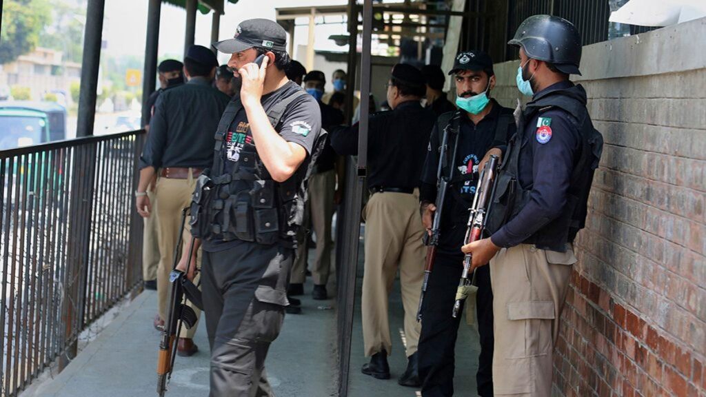 Police officers gather at an entry gate of district court following the killing of Tahir Ahmad Naseem, who was in court accused of insulting Islam, in Peshawar, Pakistan, Wednesday, July 29, 2020.