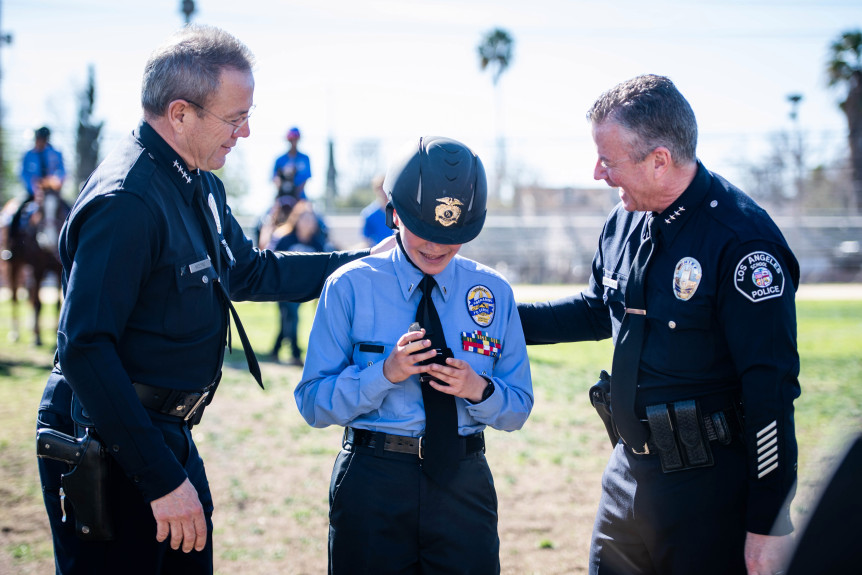 LAPD Chief Michel Moore and LASPD Chief Todd Chamberlain give Angelica Rangel, 16, a junior, her lieutenant II pins as she rises in rank during formal inspection of cadets,