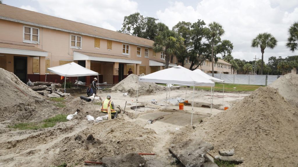 Archaeologists work to uncover graves at the former site of the Zion cemetery found underneath the Robles Park Village housing complex ,