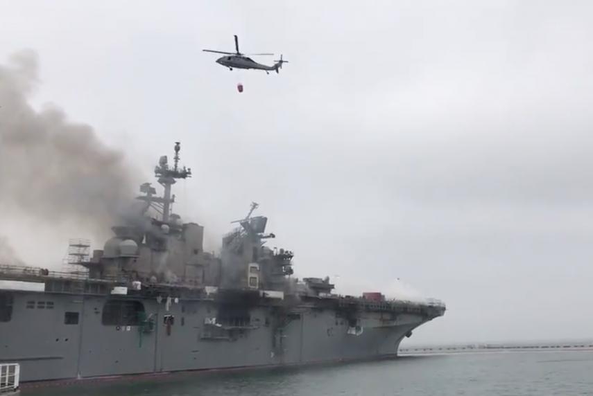 U.S. Navy helicopters assist in fighting a fire that has been burning on the SS Bonhomme Richard since Sunday morning.