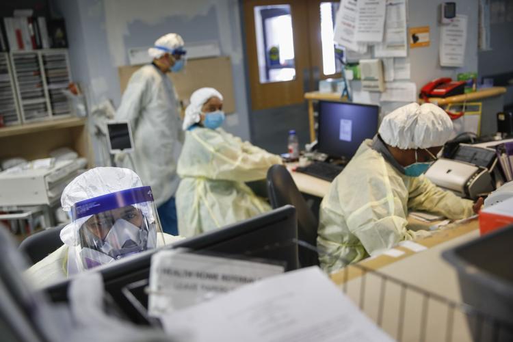 Emergency room doctors and nurses wear personal protective equipment while manning desks due to COVID-19 concerns at St. Joseph's Hospital, Monday, April 20, 2020, in Yonkers, N.Y.