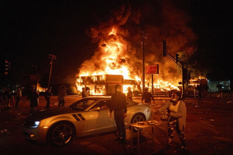 An AutoZone store burns as protesters gather outside of the Third Precinct in Minneapolis Thursday, May 28, 2020.