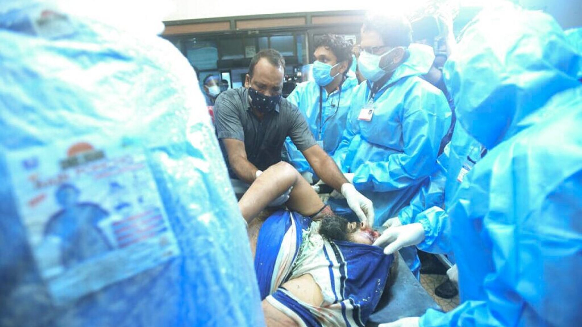 One of the injured after an Air India Express flight skidded off a runway while landing at the Kozhikode airport is brought for treatment to the Medical College Hospital in Kozhikode, Kerala state, India. 