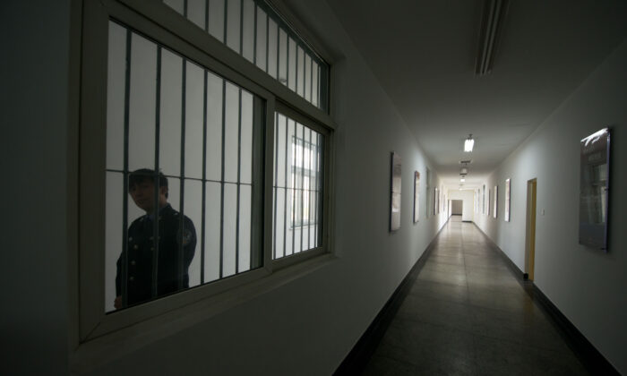 A guard looks through the window of a hallway inside the No.1 Detention Center during a government guided tour in Beijing, China on Oct. 25, 2012.