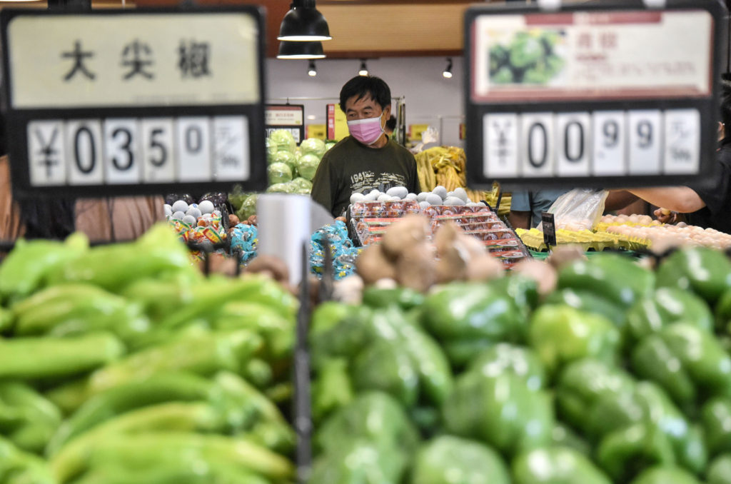 A customer buys vegetables at a supermarket in Handan in China’s northern Hebei province on August 10, 2020. 
