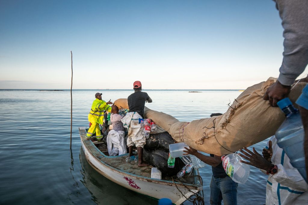 Volunteers prepare to place handmade oil barriers in the sea at the Mahébourg waterfront in Mauritius on August 12, 2020, in order to prevent a further oil spill from the MV Wakashio vessel.