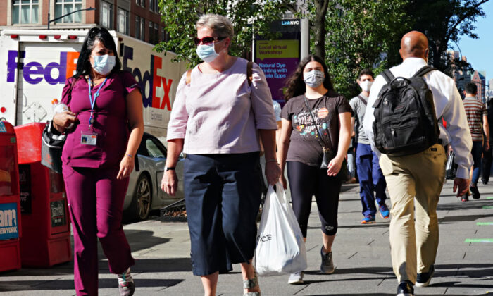 People walk while wearing protective masks as New York City moves into Phase 3 of reopening following restrictions imposed to curb the CCP virus pandemic, on July 14, 2020.