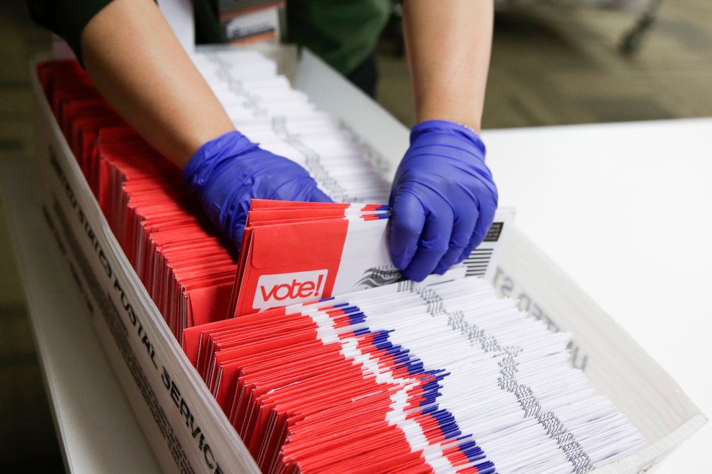 Election workers sort vote-by-mail ballots for the presidential primary at King County Elections in Renton, Wash., on March 10, 2020.