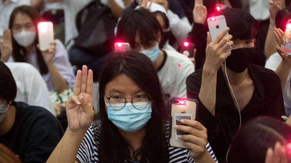 Pro-democracy students raise a three-finger symbol of resistance salute and hold mobile phones with flashlights switched on†during a protest at Chulalongkorn University in Bangkok, Thailand, Friday, Aug, 14, 2020.