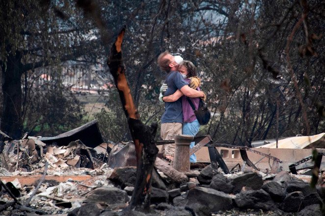Dee Perez comforts Michael Reynolds in the ruins of his home destroyed in the Almeda Fire in Talent, Oregon.