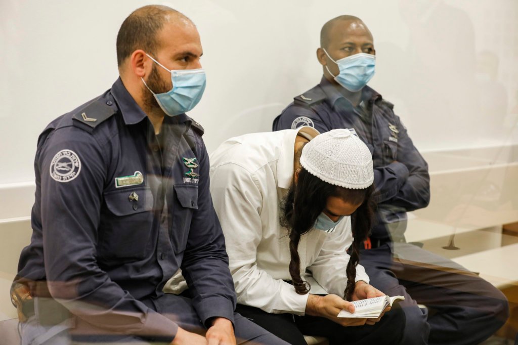 Amiram Ben-Uliel, a Jewish extremist convicted for the Duma arson murder reads while waiting during a sentencing hearing at the central district court of Israel’s central city of Lod on June 9, 2020