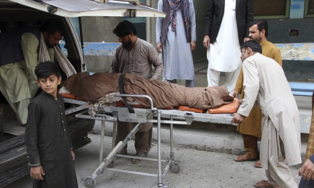 The body of a woman is taken away from the Jalalabad stadium on Wednesday.