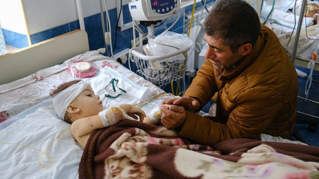 A man speaks with his child, wounded during shelling, in Stepanakert, the self-proclaimed Republic of Nagorno-Karabakh, Azerbaijan, Monday, Sept. 28, 2020.