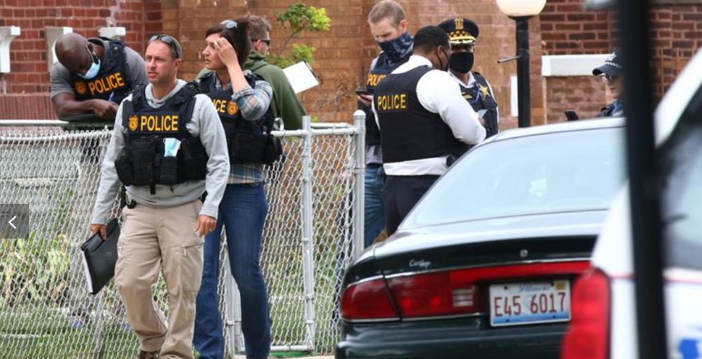Police officers from the U.S. Postal Service and Chicago police detectives investigate the shooting of a mail carrier in the 9100 block of South Ellis Avenue on Sept. 10, 2020. The mail carrier was taken to the University of Chicago Medical Center in critical condition, according to police.