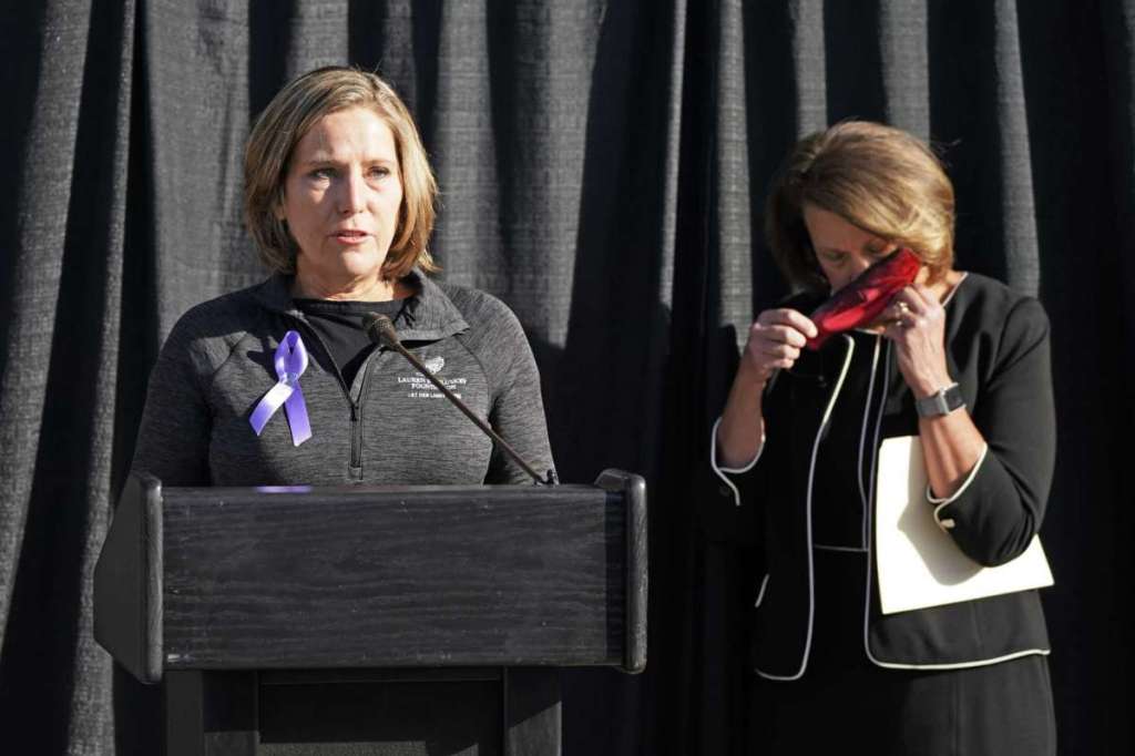University of Utah President Ruth Watkins, right, puts on her mask as Jill McCluskey, the mother of slain University of Utah student-athlete Lauren McCluskey speaks during a press conference announcing they have reached a settlement in their lawsuit against the university Thursday, Oct. 22, 2020,