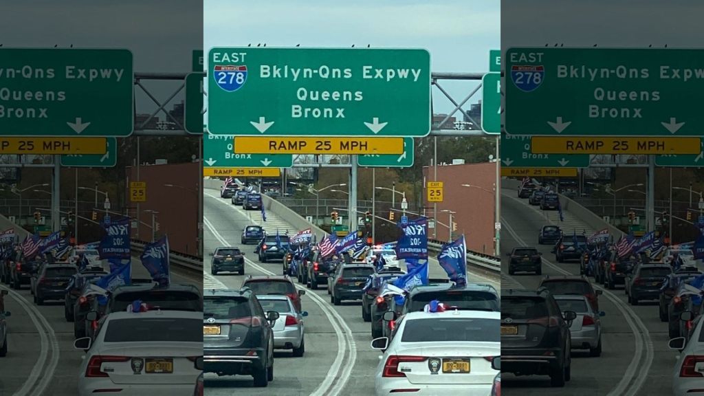 A caravan of Trump supporters driving through NYC, prominently displaying Trump 2020 flags.