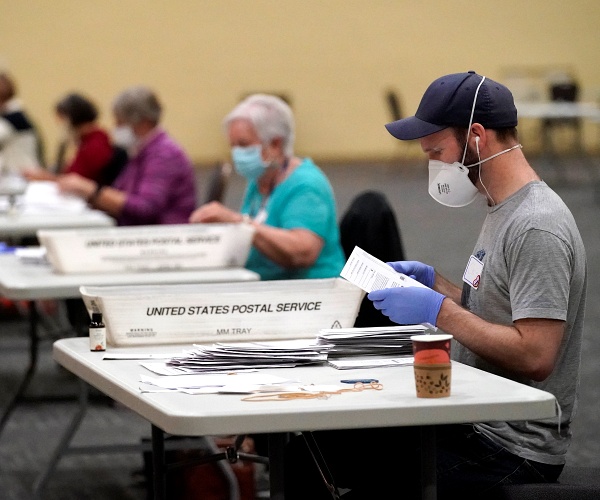 Workers prepare main-in ballots for counting, Wednesday, Nov. 4, 2020, at the convention center in Lancaster, Pa., following Tuesday's election.