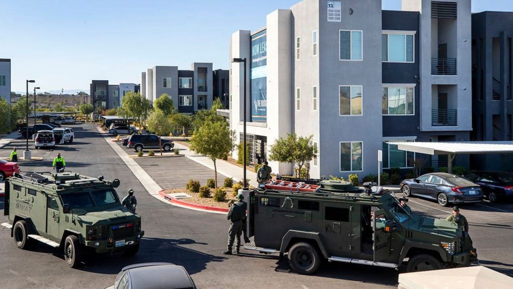 Henderson Police officers and SWAT vehicles are shown at the scene of a fatal shooting in an apartment complex in Henderson, Nevada. Four people were killed including the suspect in the shooting, police said.