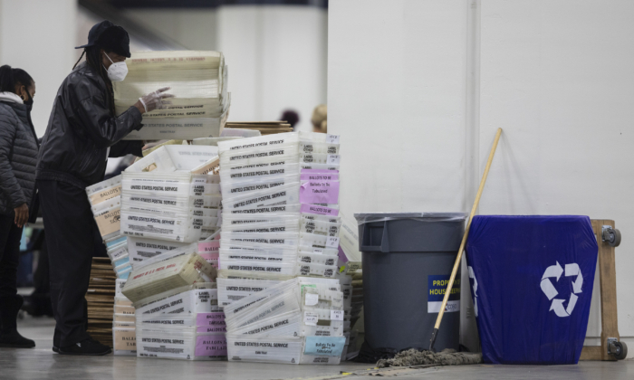 A worker with the Detroit Department of Elections helps stack empty boxes used to organize absentee ballots after nearing the end of the absentee ballot count at the Central Counting Board in the TCF Center in Detroit, Mich., on Nov. 4, 2020.
