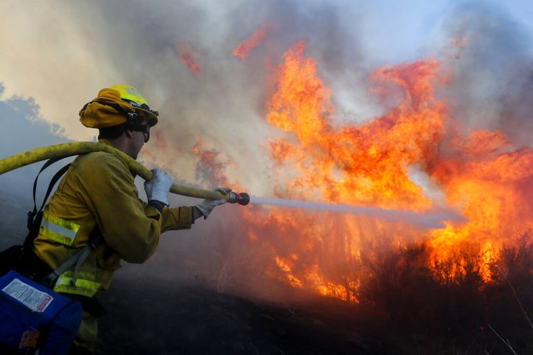 A firefighter battles the Bond Fire in Silverado, Calif., Thursday, Dec. 3,