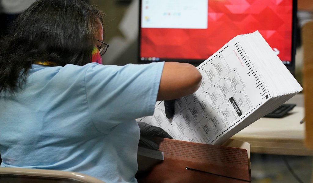 A county election worker scans mail-in ballots at a tabulating area at the Clark County Election Department, Thursday, Nov. 5, 2020, in Las Vegas. (AP Photo/John Locher)